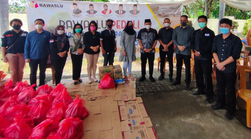 MOCHAMMAD AFIFUDDIN MENYERAHKAN BANTUAN BAWASLU RI KEPADA KORBAN BANJIR DI MANADO